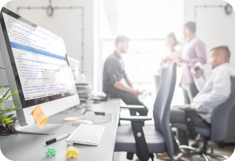 Example of web design Brisbane with designers in the background talking, a computer in the foreground